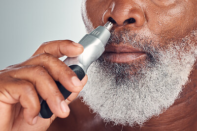 Buy stock photo Black man, grooming and nose hair removal with an electric trimmer for shave, beauty and skin care. Face of African person with tools for nasal hygiene, facial routine or maintenance grey background