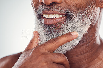 Buy stock photo Hand, beard and smile with a senior black man grooming in studio on a gray background for beauty or skincare. Skin, hygiene and cosmetics with a mature male indoor to promote facial hair maintenance
