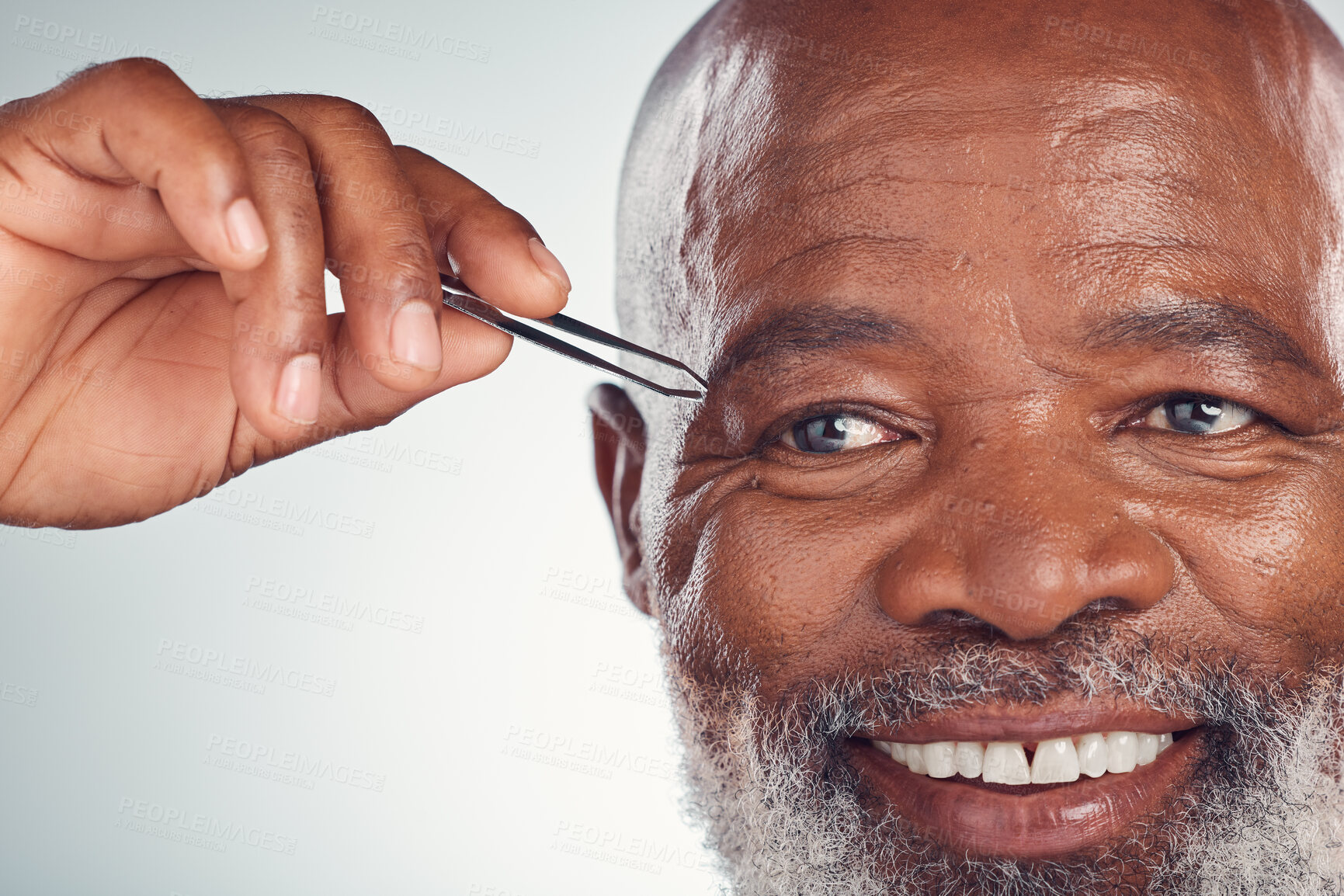 Buy stock photo Grooming, smile and black man with tweezers for hair removal isolated on grey studio background. Cleaning, routine and senior African person with a product on face for shaping eyebrows on a backdrop