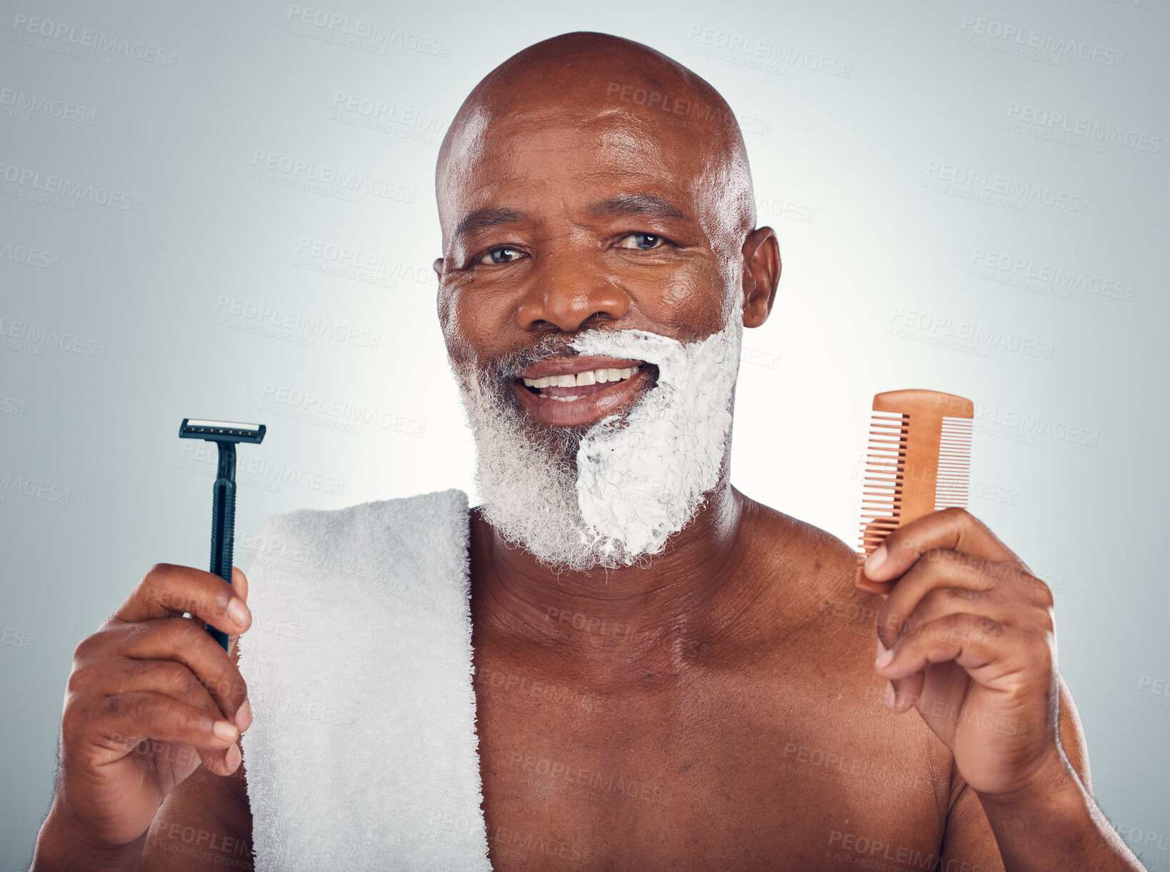 Buy stock photo Black man, portrait smile and beard for shaving with razor, cream and comb for skincare, grooming or self care on a gray studio background. Happy African American male with shave kit for clean facial