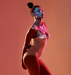 Portrait, beauty and neon with a model black woman in studio posing in underwear on an orange background. Aesthetic, art and fashion with an attractive young female standing on a kaleidoscope wall
