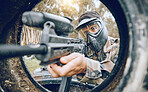Paintball, gun and man with focus, safety uniform and extreme sports for activity, gear and competition. Teamwork, male player or guy with camouflage, shooting paint rifle or military weapon for game