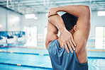 Rear view, stretching and man at swimming pool for training, cardio and exercise, indoor and flexible. Hand, back and swimmer stretch before workout, swim and fitness routine, warm up and preparation