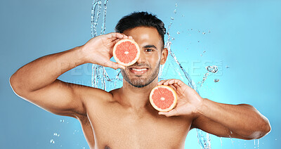 Buy stock photo Man, portrait smile and fruit for skincare, healthy nutrition or vitamin C and hydration against a blue studio background. Happy male holding grapefruit for natural organic diet or body wellness