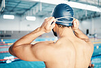 Swim cap, athlete and back of a man preparing for competition, exercise or training in a pool. Sports, fitness and male swimmer standing ready for a swimming workout, challenge or sport race.