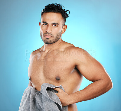 Buy stock photo Cleaning, towel and portrait of a man after a shower isolated on a blue background in a studio. Sexy, grooming and muscular model on a backdrop after washing body for hygiene, skincare and health