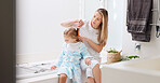 Hair care, mother and girl in bathroom, with brush and bonding to connect, talking and for fun. Female, lady and daughter or kid doing development, child growth and discussion together at home loving