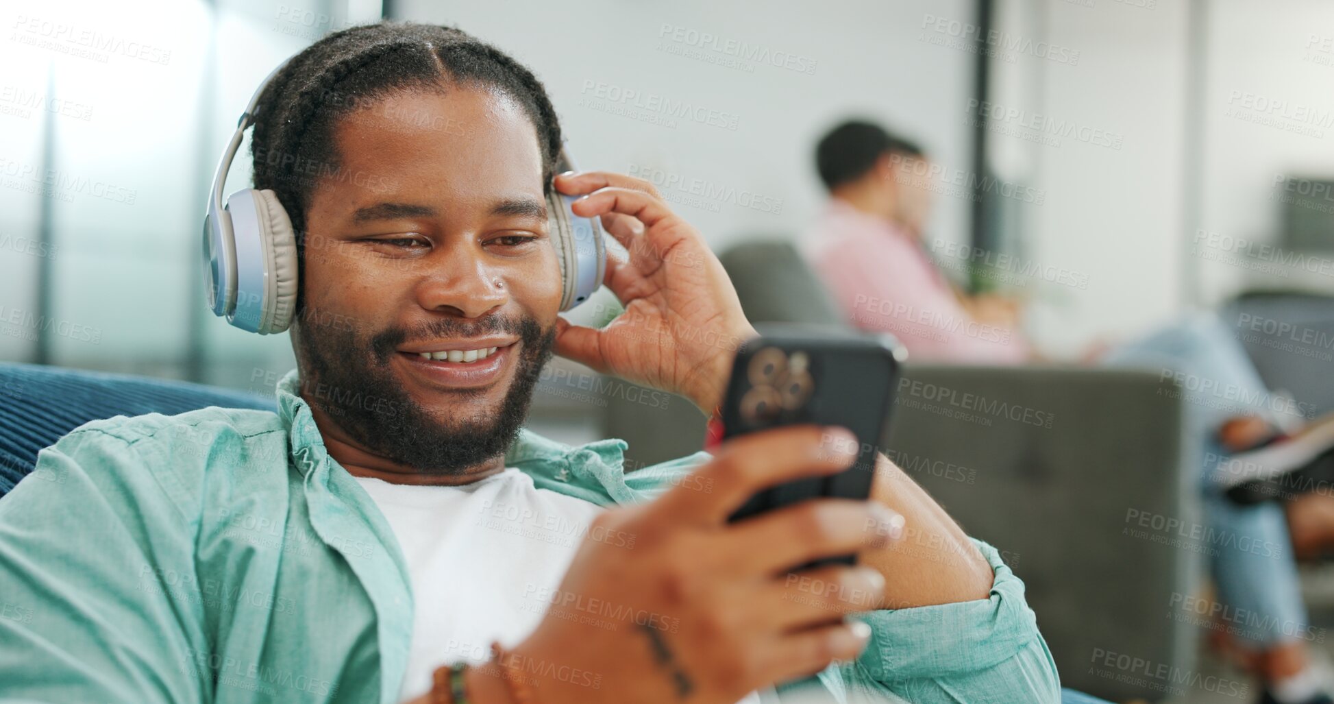 Buy stock photo Headphones, relax and black man with a phone on a sofa in living room listening to music and chatting. Rest, chill and African guy streaming radio, album or playlist while relaxing on couch at home.