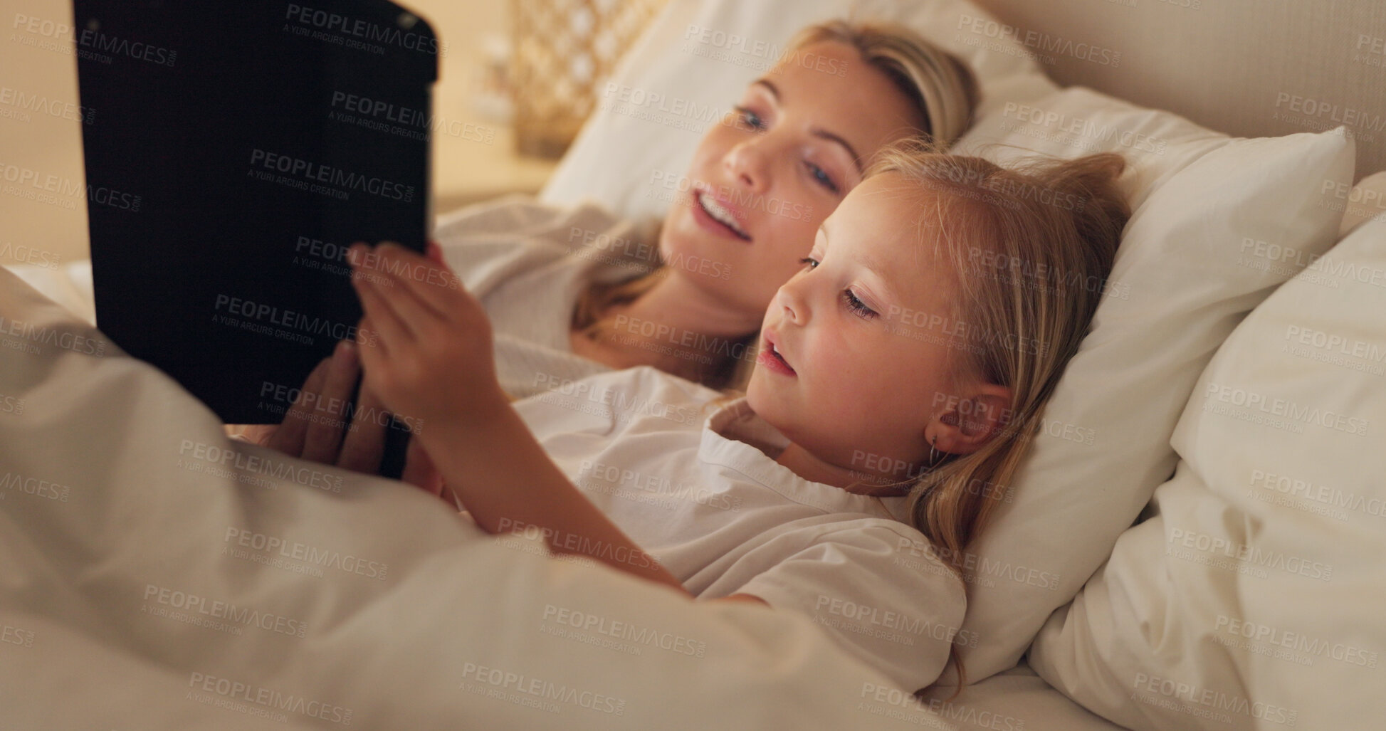 Buy stock photo Mom, girl and tablet on bed, night and reading with learning, video or movie to relax together in family home. Bedtime story, mother and daughter in bedroom, fantasy and care with love for bonding