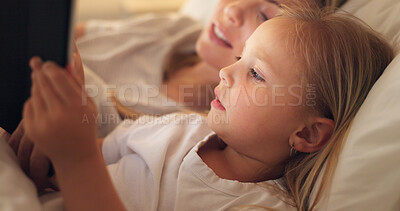 Tablet, mother and child on the internet in bed, streaming a movie or reading a book on the web at night. Education, learning and games on technology for a girl and her mom together in the bedroom