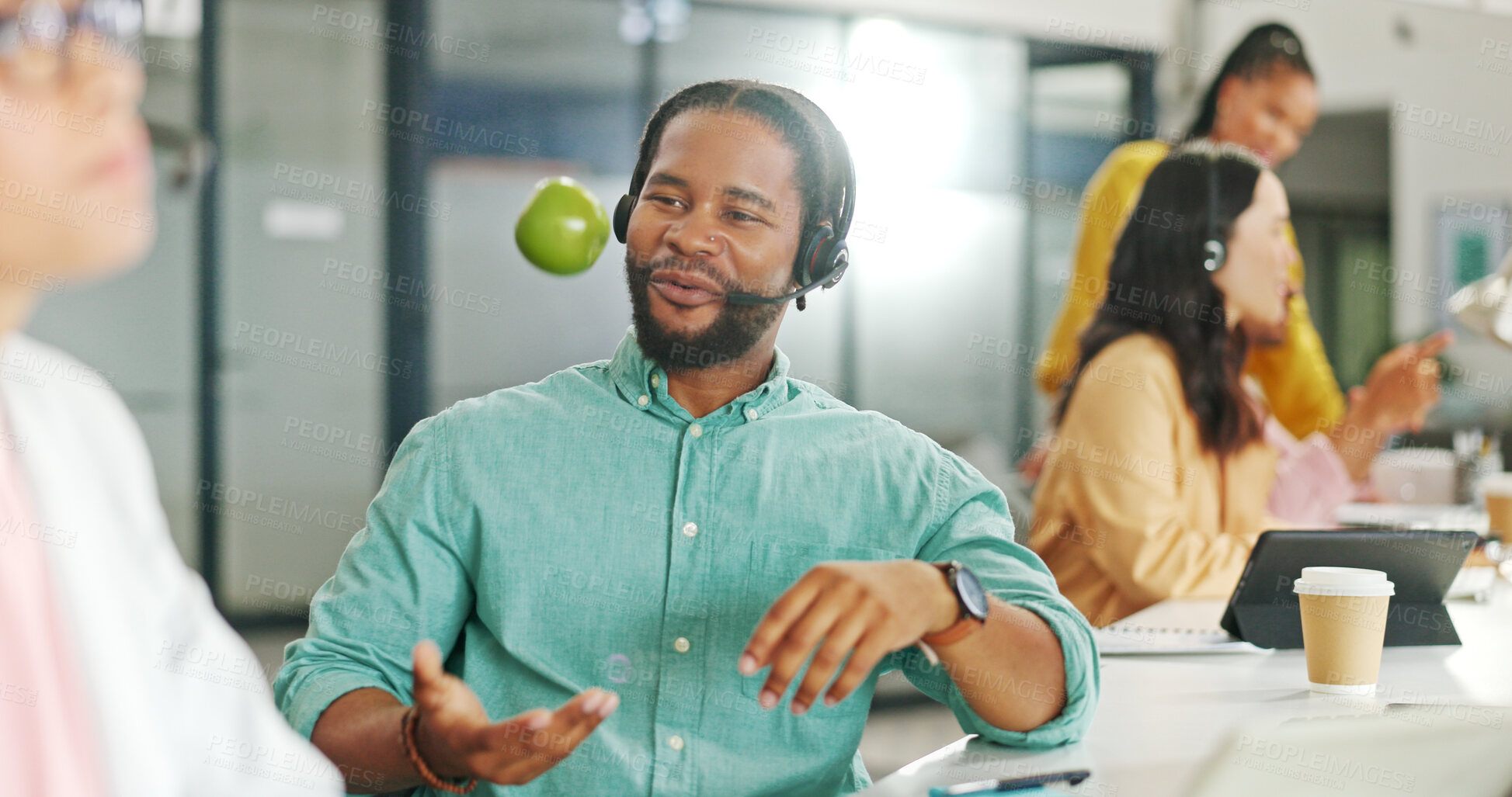 Buy stock photo Apple, business and black man with telemarketing, sales and communication with technical support in a workplace. Person, coworkers and consultant with a fruit, call center and employee with help desk