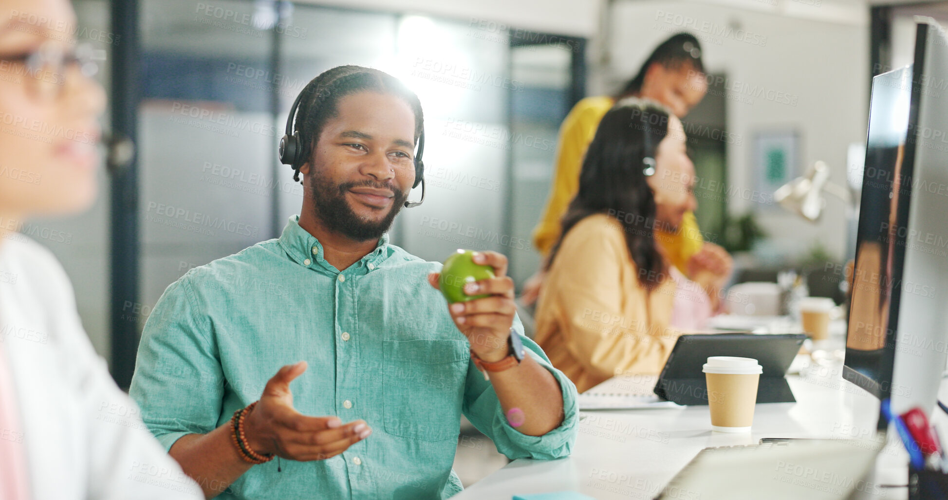 Buy stock photo Call center, customer service and business black man with an apple while working on a computer for sales. Telemarketing, contact us and online support with a male employee as a consultant with fruit