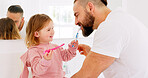 Dental health, father and girl for brushing teeth, together or laugh in bathroom in home to have fun. Oral hygiene, dad and daughter with tooth brush, being happy or bonding for happiness or in house