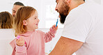 Happy family, dental and brushing teeth with girl and father in bathroom for hygiene, learning and grooming. Love, teeth and oral care by parent with daughter play, laugh and cleaning in their home