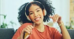 Black woman, dancing and headphones on sofa, being content and singing words in living room. Young girl, headset and digital device for contemporary dancer, moving with rhythm and relax on break.