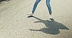 Feet, dancing and woman in city street for celebration, achievement or happy success with shadow or silhouette on asphalt road. Energy, freedom and urban hip hop dancer student girl legs and sneakers