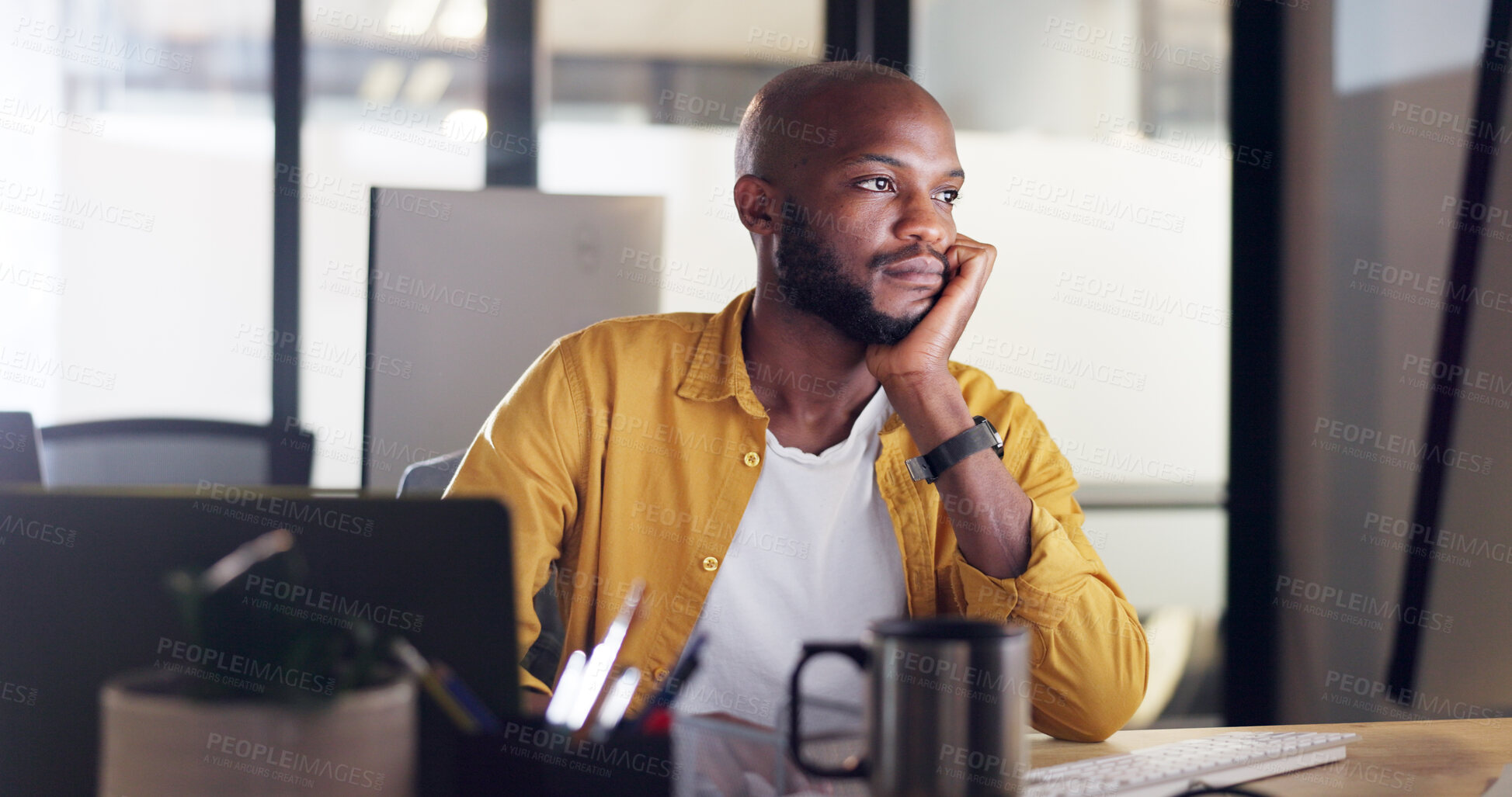 Buy stock photo Bored, tired and young black man in the office on computer working on a deadline project. Exhausted, fatigue and overworked African male designer doing creative research by his desk in the workplace.