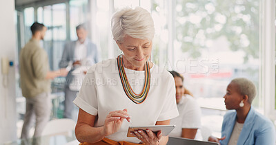 Business woman, senior and digital tablet for leader planning, thinking and research while in business meeting. Mature woman, internet and search while leading a meeting with creative group in office
