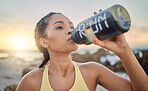 Health, fitness and woman drinking water at beach after running, exercise or workout. Sports, hydration and thirsty female athlete with water bottle on break after training for wellness at sunset.