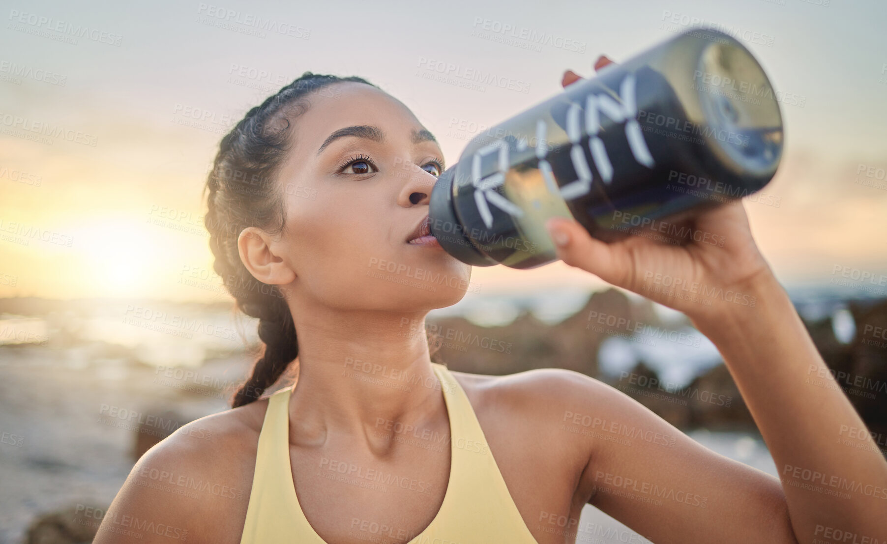 Buy stock photo Health, fitness and woman drinking water at beach after running, exercise or workout. Sports, hydration and thirsty female athlete with water bottle on break after training for wellness at sunset.