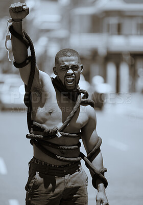 Buy stock photo Protest, fist and man in rope and handcuffs in city protesting against discrimination, oppression or slavery and racism. Black lives matter, justice and angry male in street fighting for human rights