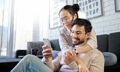 Buy stock photo Phone, love and diversity with a couple in their home, bonding while browsing social media in the living room. Mobile, communication or internet with an interracial man and woman together in a house