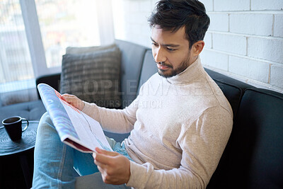 Buy stock photo News, newspaper and man reading article in a home, house or apartment on the weekend sitting on a couch or sofa. Mexican, relax and young person enjoying free time in living room in the morning