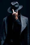 Mystery, middle finger or dark man in stylish outfit, fashion or suit posing isolated against a studio black background. Person, style and fashionable male or gangster with offensive gesture