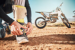 Extreme, motorcycle and man tying laces in nature for adventure, holiday and race in the countryside. Road, travel and biker ready with shoes for a journey on a motorbike on a dirt road for freedom