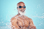 Water, face and black man with goggles on blue background for wellness, skincare and cleaning. Facial treatment, shower and senior male isolated with splash for hydration, moisturizing and hygiene 