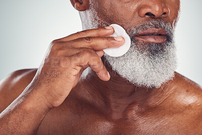 Buy stock photo Beauty, cotton and wipe by senior man cleaning skin for skincare, grooming and self care isolated in studio white background. Cleanse, scrub and smooth or glow face by old person or model as wellness