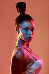 Neon lighting, fashion and portrait of a woman with makeup isolated on a brown studio background. Cyberpunk, futuristic and face of a model with creative beauty, color and glow on a backdrop