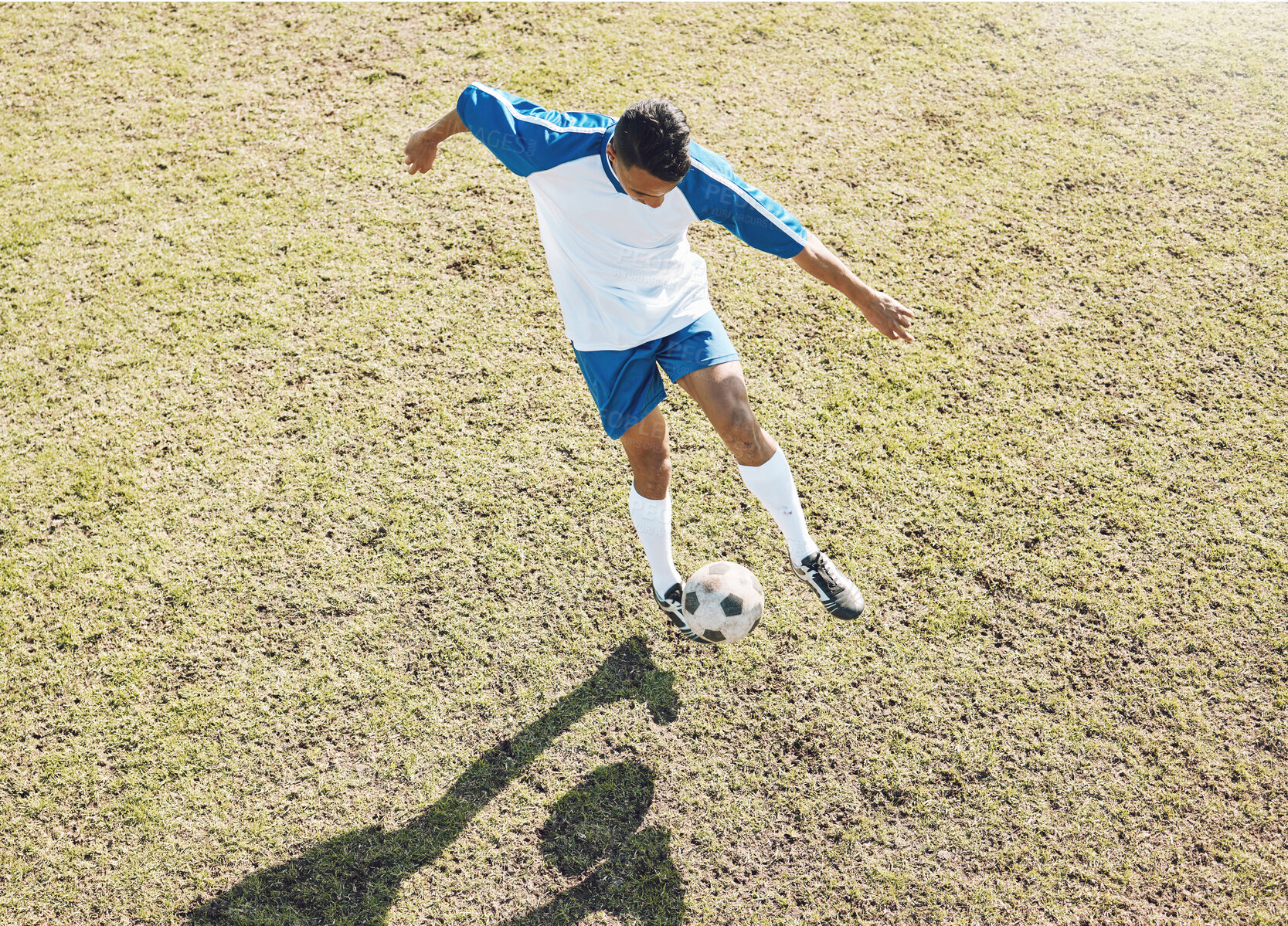Buy stock photo Football ball, soccer player and athlete doing sports cardio, training and exercise on a grass field. Kick, game and workout outdoor with fitness and running for wellness and health with energy