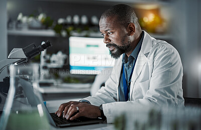 Buy stock photo Scientist man, laptop and doing research in a laboratory with information technology and data analytics. Black person or doctor typing online at night for medical science development on internet