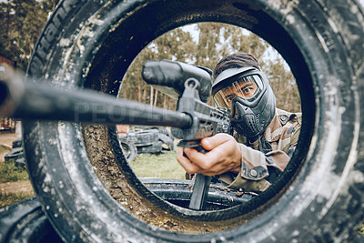 Buy stock photo Gun aim at target with tire, paintball and man outdoor, action on battlefield and soldier focus during war game. Extreme sport, weapon and military mission, exercise and fitness with determination