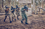 Paintball, team work or men running in a shooting game with speed or fast action on a fun battlefield. Mission focus, military or people with guns for survival in a competition in nature or forest