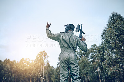 Buy stock photo Paintball, rock hand sign or man in a shooting game playing on a fun battlefield with pride. Success, war winner or soldier with weapon or gun for in celebration of winning survival competition 