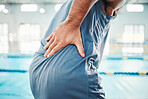 Pain in back, sports and man by swimming pool with injury, muscle ache and inflammation from training. Health, medical care and male with accident, emergency or body bruise from fitness or exercise