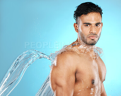 Buy stock photo Water splash, portrait and man for beauty, skin and skincare cleaning his body, muscle and topless. Mexican, strong and serious model with moisture, cleanse and hydration in studio blue background