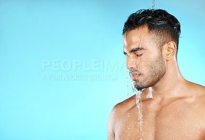 Buy stock photo Water splash, shower and man in studio for skincare, wellness and grooming on blue background. Cleaning, beauty and moisture by Mexican model relax with luxury, routine and body care while isolated