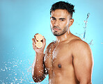 Lemon, skincare and portrait of man in water splash in studio for wellness, cleaning and fresh on blue background. Fruit, product and beauty by male model relax with luxury, facial and skin treatment