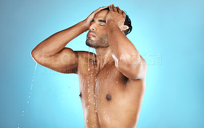 Buy stock photo Hair, shower and man in water splash for skincare, grooming and washing in studio on blue background. Cleaning, beauty and male model relax in luxury, treatment and haircare routine while isolated