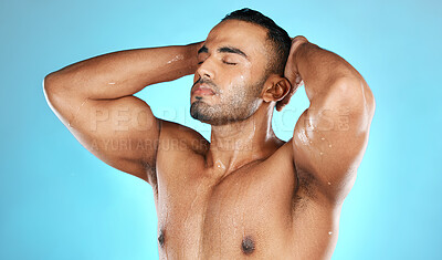 Buy stock photo Shower, hair and man in water splash for skincare, grooming and washing in studio on blue background. Cleaning, beauty and male model relax in luxury, treatment and haircare routine while isolated