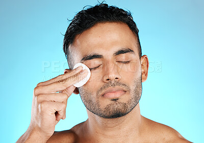 Buy stock photo Man, cotton and man in studio for skincare, wellness and cleaning while grooming on blue background. Faical, pad and male skin model relax with luxury, cosmetics and product, hygiene and isolated