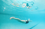 Swimming, fitness and sports with a woman underwater in a pool for cardio or endurance exercise. Water, swimwear and health with a female swimmer during a workout or competitive watersports game