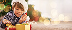 Boy, child or opening christmas present on living room floor, house or home with mockup, bokeh or mock up space. Smile, happy or festive kid with gift box in celebration, holiday or tradition giving