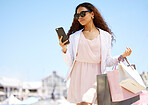 Shopping, phone and woman in city for a sale, ecommerce or luxury brand discount. Person with smartphone for designer fashion, retail and paper bag walking outdoor for travel contact or banking app