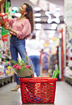 Shop floor aisle, grocery basket with flowers, black woman or box for choice, sale or discount in valentines promotion. Young african female, low angle and groceries shelf for product deal in store
