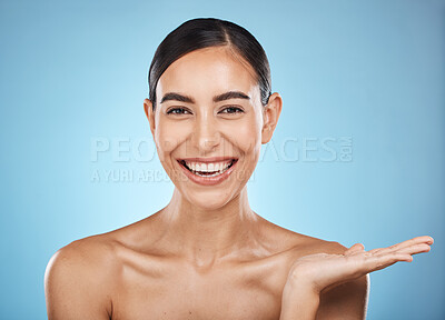 Buy stock photo Face, beauty skincare and woman with product placement in studio isolated on a blue background. Makeup portrait, cosmetics and female model with marketing, advertising or branding space for mockup.