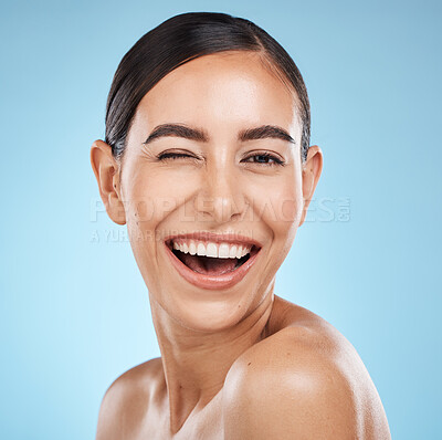 Buy stock photo Face, wink and beauty skincare of woman in studio isolated on blue background. Portrait, makeup and cosmetics of happy female model with healthy, glowing and flawless skin after spa facial treatment.